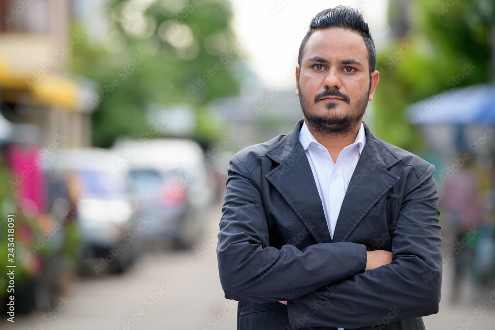 Bearded Indian businessman with arms crossed outdoors Bearded Indian businessman with arms crossed outdoors