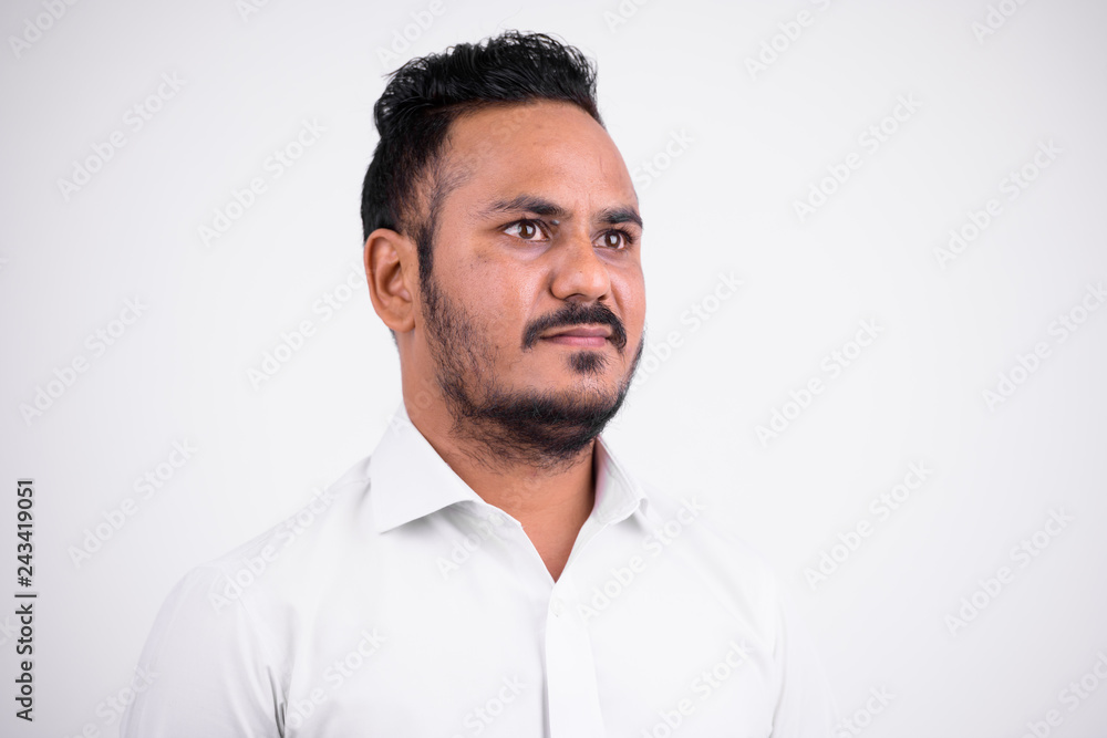 Face of bearded Indian businessman thinking and looking up Face of bearded Indian businessman thinking and looking up