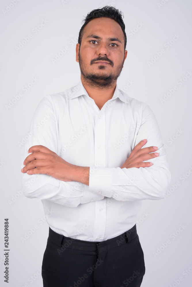 Studio shot of bearded Indian businessman with arms crossed Studio shot of bearded Indian businessman with arms crossed