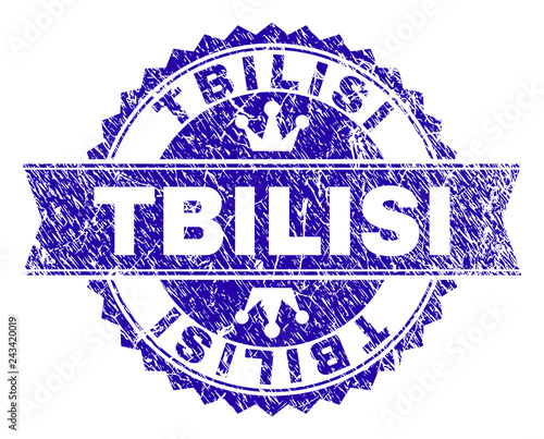TBILISI rosette stamp watermark with grunge texture. Designed with round rosette, ribbon and small crowns. Blue vector rubber watermark of TBILISI caption with dust texture.