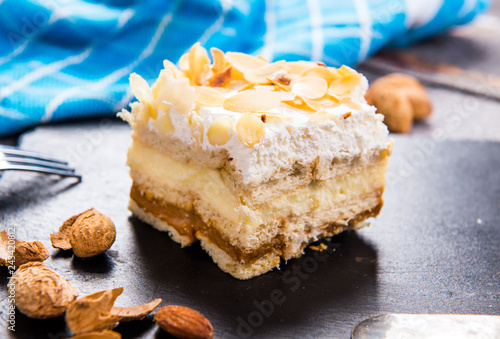 Homemade cake with whipped cream, almonds petals, toffi cream photo