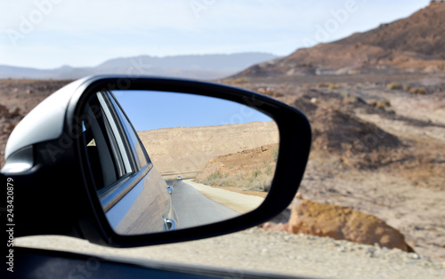side view mirror of a car , on road inauto,automobile,back,background,behind,blue,car,desert,drive,highway,landscape,looking,mirror,motion,nature,outdoor,rear,reflection,road,route,side,sky the desert