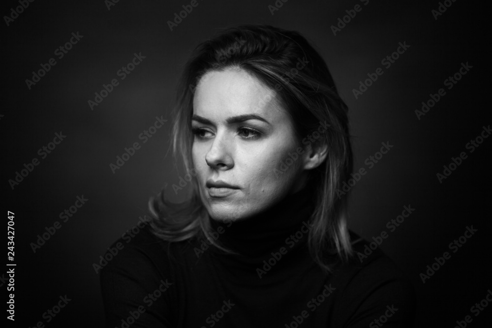 Dramatic black and white portrait of a beautiful woman on a dark background Dramatic black and white portrait of a beautiful woman on a dark background