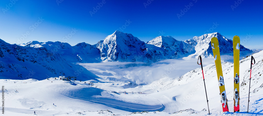 Ski in winter season, mountains and ski touring backcountry equipments on the top of snowy mountains in sunny day. South Tirol, Solda in Italy.