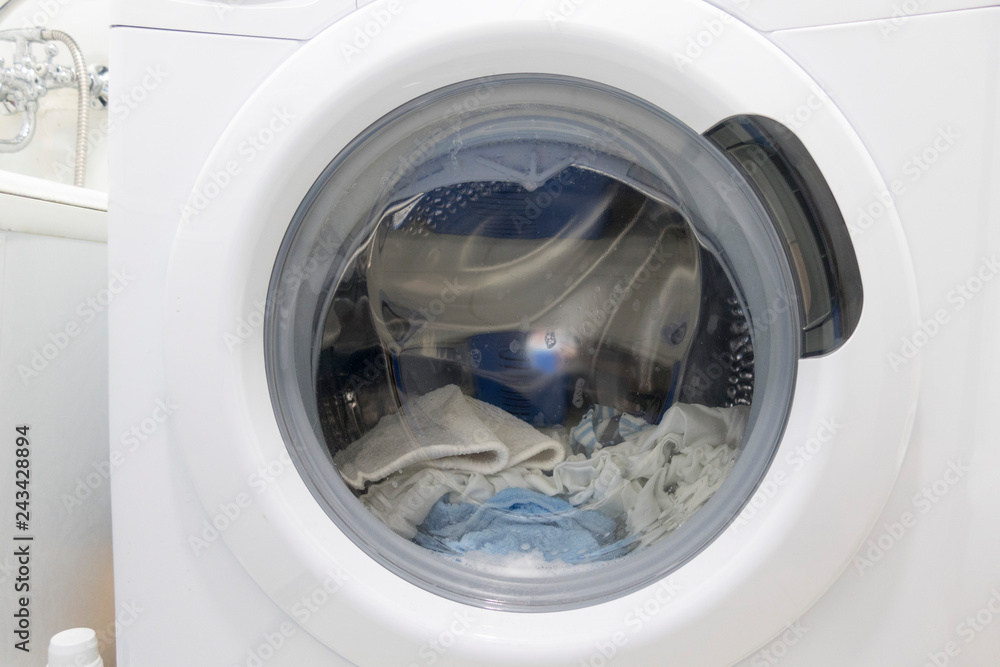 Drum washing machine with wet laundry, close-up. Drum washing machine with wet laundry, close-up.