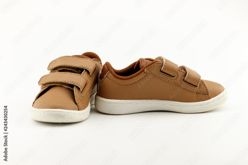 Concept encourage children to play sport, exercise for a healthy body, shoes of small baby shoes next to ball isolated on white background. Concept encourage children to play sport, exercise for a healthy body, shoes of small baby shoes next to ball isolated on white background.