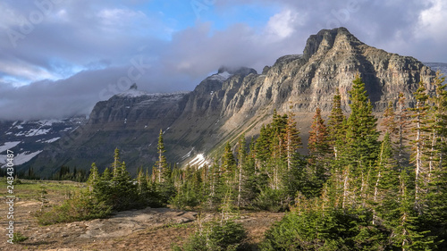 late afteroon light on mt pollock and bishops cap on a stormy day at glacier national park in montana, usa