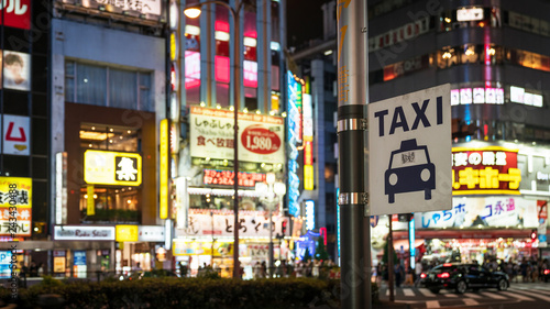 Taxi sign under bright neon and advertisement lights at Kabukicho in the Shinjuku, Tokyo, Japan photo