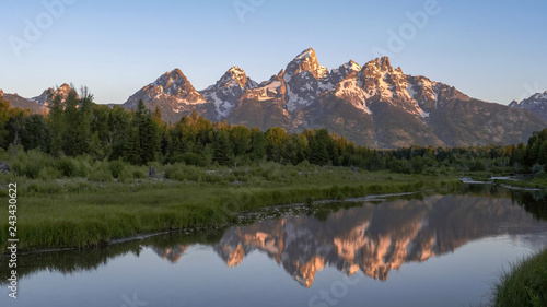 a sunrise shot of grand teton and a stream at schwabacher landing in grand teton national park in the united states © chris