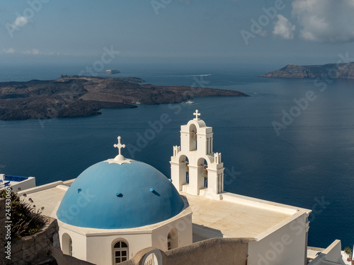 blue church dome and three bells in fira on the island of santorini, greece