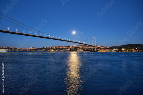 Bosphorus Bridge on background of night coast under bright moon