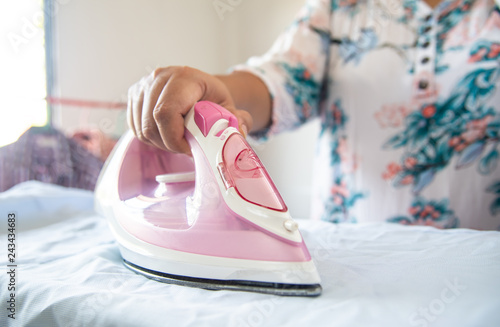 Close up of woman ironing clothes on ironing board