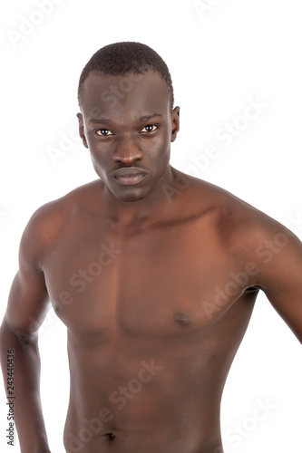 Young buff Sudanese man with a naked torso in khaki trousers looking to camera with peircing eye contact, hands on his hips in portrait format with copy space isolated on white. You want me.