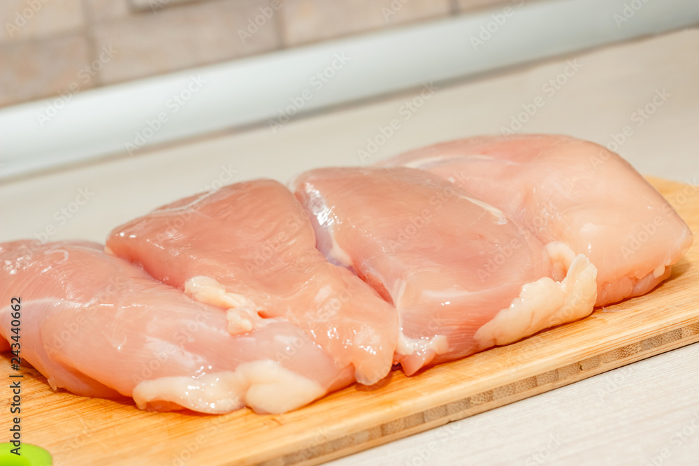 Raw skinless chicken breast fillets on a cutting board Raw skinless chicken breast fillets on a cutting board