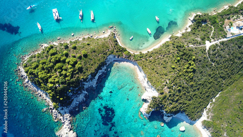 Aerial drone bird's eye view photo of sail boats docked in tropical caribbean paradise bay with white rock caves and turquoise clear sea photo