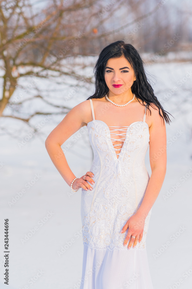 Arabic sexy woman in bright white chiffon long dress at snowy field. Evening fashionable dress, modern romantic bride ,winter fairytale Arabic sexy woman in bright white chiffon long dress at snowy field. Evening fashionable dress, modern romantic bride ,winter fairytale