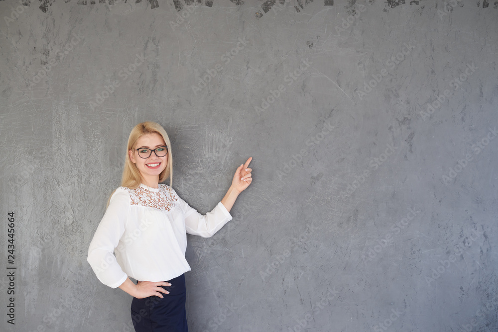 Businesswoman pointing finger on gray background Businesswoman pointing finger on gray background