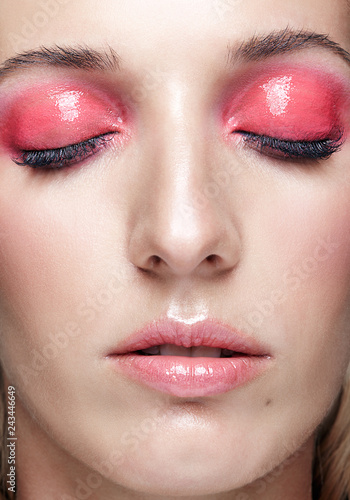 Closeup macro shot of female face and pink smoky eyes makeup