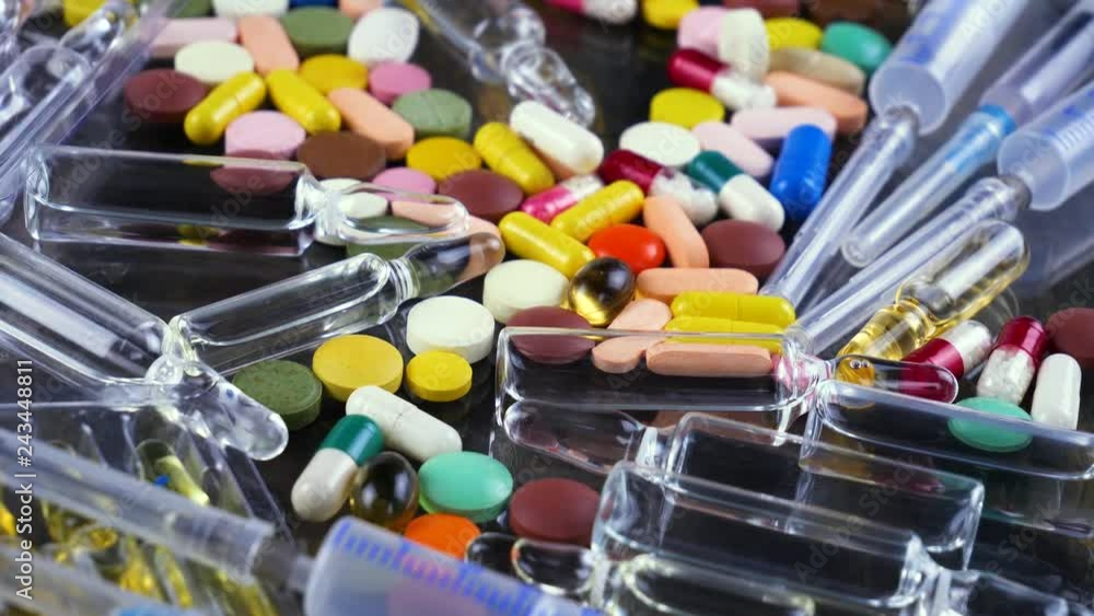 Medical pills and syringes for injection rotate on the table Medical pills and syringes for injection rotate on the table