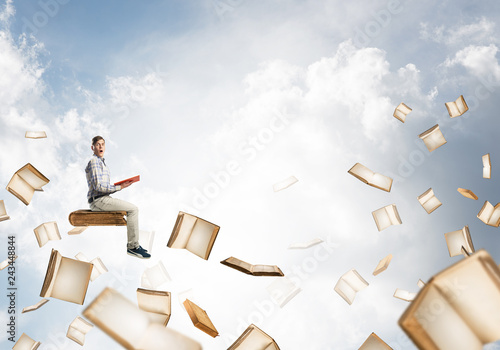 Man reading book and many of them flying in air