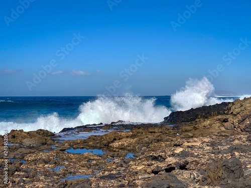 Ocean waves crashing of coast rocks on Fuerteventura island