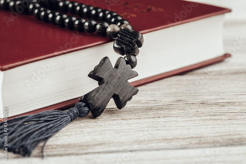 Bible and a crucifix on an old wooden table. Religion concept.