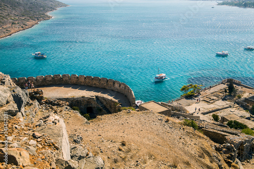 View from the Spinalonga fortress on the island. Boat trips to the island of lepers. Ships on the sea at the edge of the island.