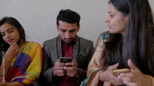 Pan across four friends occupied on their mobile phone screens while of them tries to talk and get their attention without success