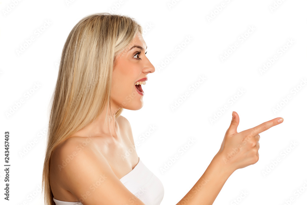 Exited young woman pointing on white background Exited young woman pointing on white background