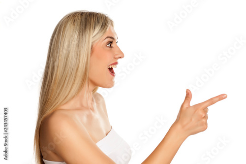 Exited young woman pointing on white background