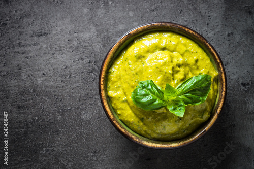 Pesto sauce with ingredients on dark stone table. 