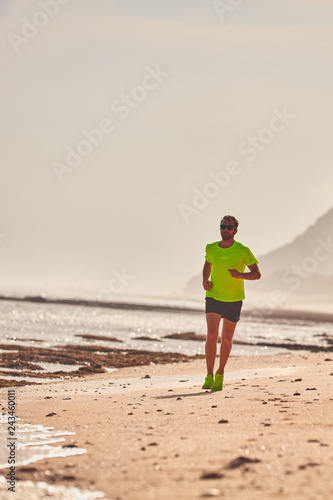 Man running / jogging on a tropical exotic beach. © astrosystem