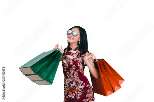 Asian woman wearing chinese dress hold shopping bag cheongsam,qipao smile in chinese new year on white isolated background