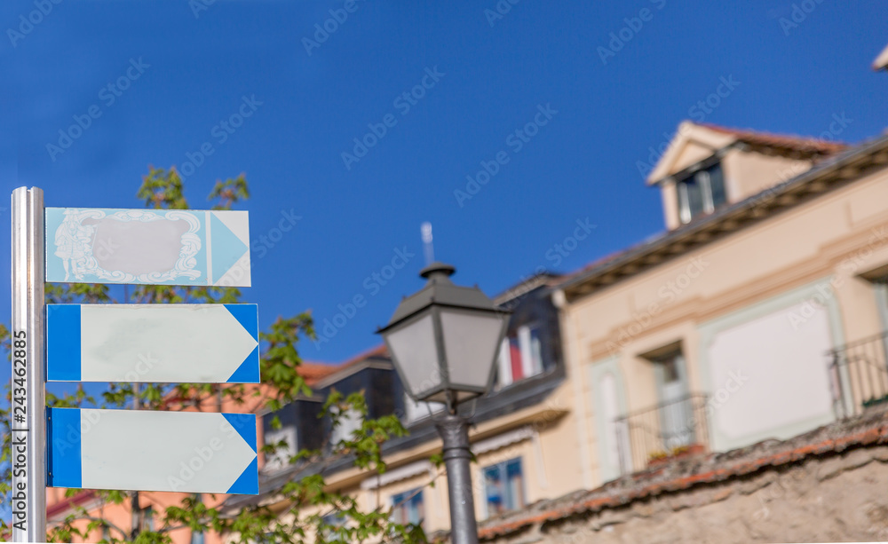 Classic style posters hanging on a metal pole with some buildings in the background