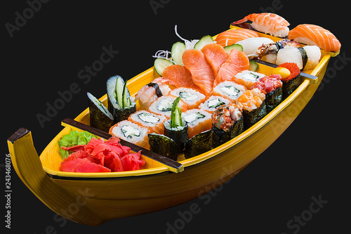 Sushi set in a wooden boat on a black background