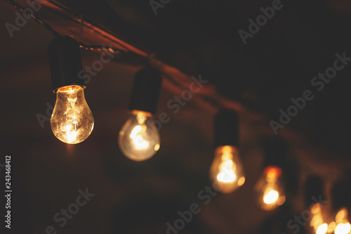 a garland of incandescent bulbs with warm light, retro toned