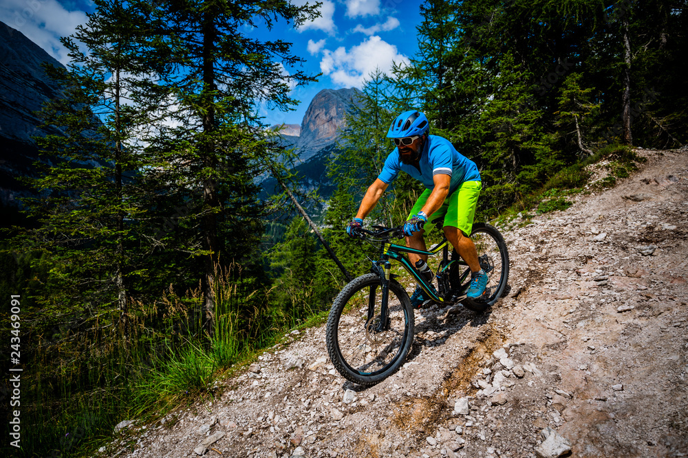 View of cyclist riding mountain bike on single trail in Dolomites, Cinque Torri, South Tirol, Italy View of cyclist riding mountain bike on single trail in Dolomites, Cinque Torri, South Tirol, Italy