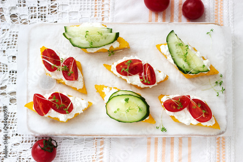 Vegetarian canapes from polenta with cheese, vegetables and cress on a light background. Rustic style. photo