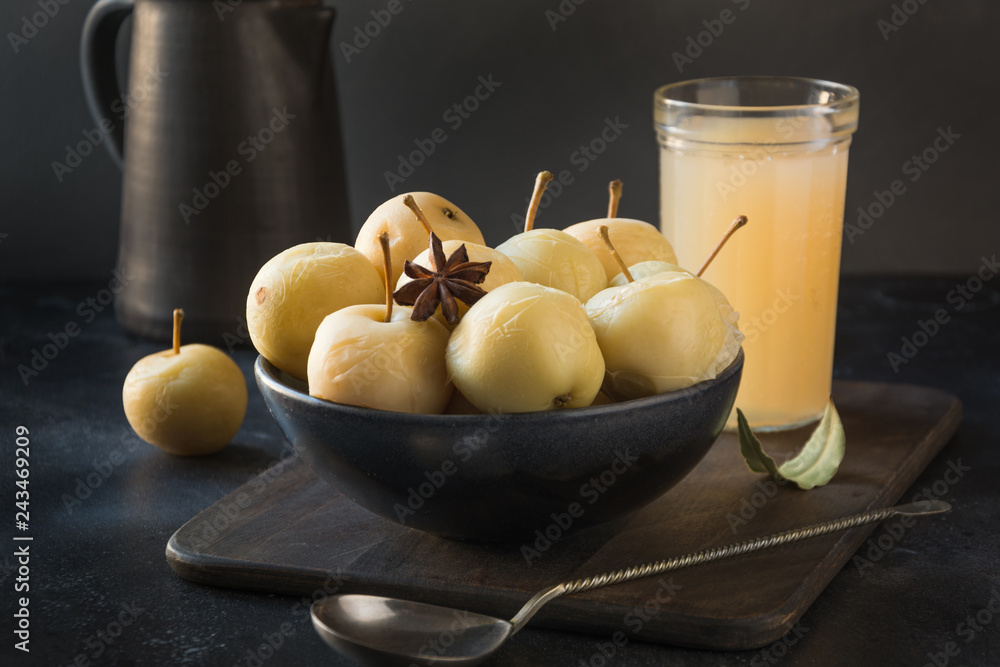 Pickled apples in bowl and apple sidr on dark stone table. - obrazy, fototapety, plakaty 