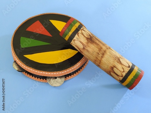 Close-up of two colorful handmade Brazilian percussion instruments: pandeiro (tambourine) and 