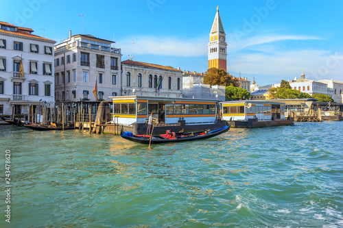 Gondolier near a vaporetto station and San Marco Campanile in Venice, Italy © AlexAnton