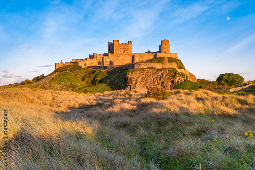 Bamburgh, United Kingdom - August 3, 2017: View of Bamburgh Castle at sunset. Copy space in sky.