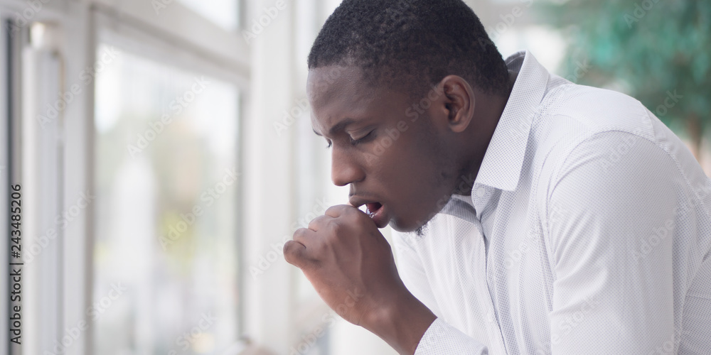 Sick African man coughing; Portrait of ill black man cough due to cold, flu, allergy, polluted
