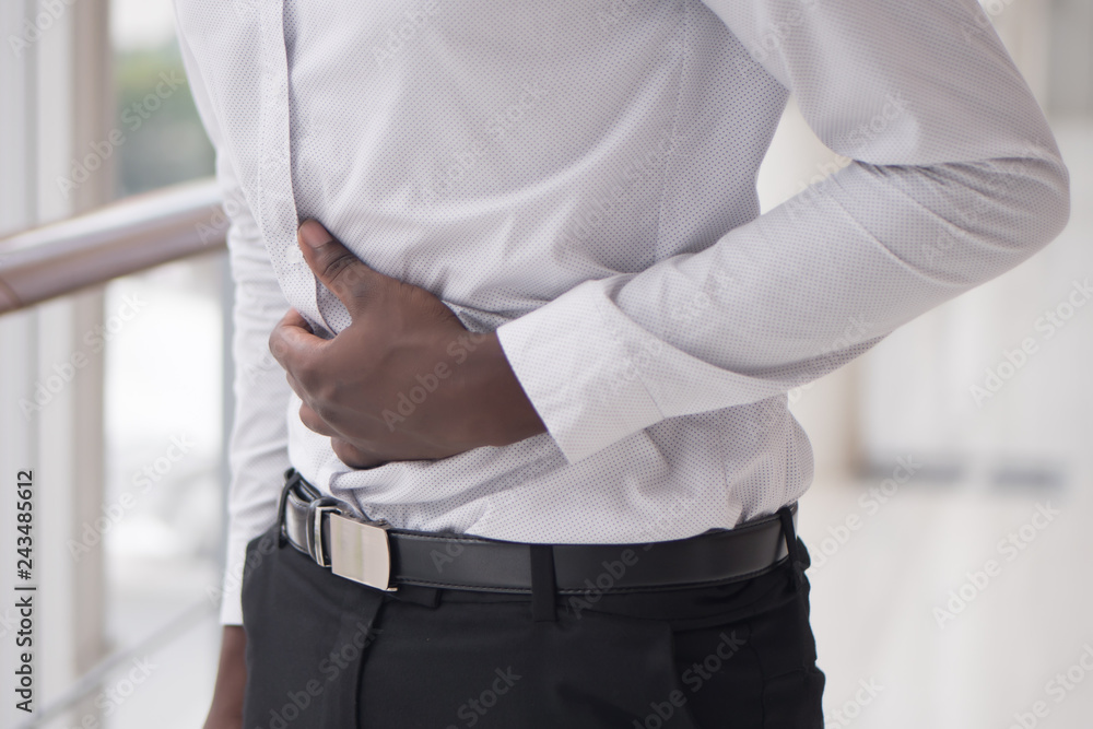 African man suffers from stomachache; sick black man with stomachache