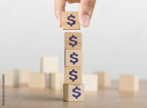 Business growth, increase profit, increase income or saving concept. Hand arranging wooden blocks with the US Dollar symbol.