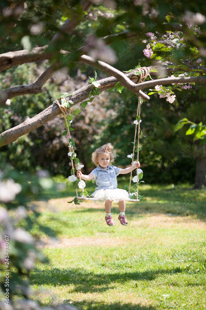 Little cute girl swinging on teeter in summer park, portrait Little cute girl swinging on teeter in summer park, portrait
