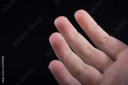 Four fingers of a human hand partly seen in view photo