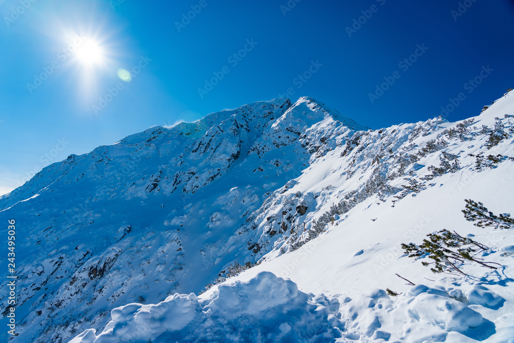 snow mountain peak with clear sky and sun flares pirin bulgaria