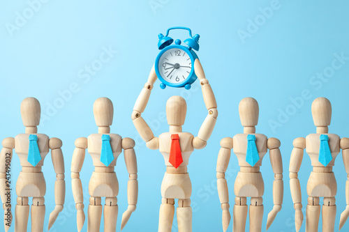 Time management. Man in tie holds an alarm clock in his hand.