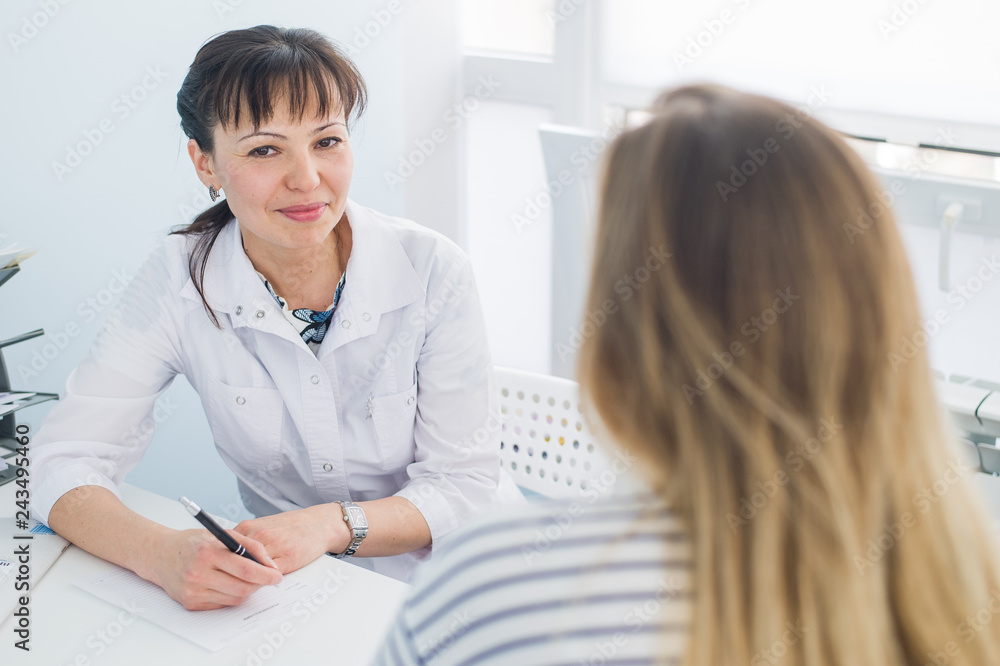 Female doctor and patient talking in hospital office. Health care and client service in medicine Female doctor and patient talking in hospital office. Health care and client service in medicine